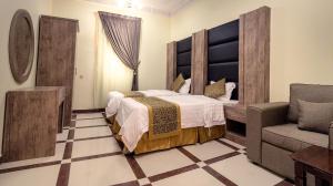 艾卜哈Rose Palace For Residential Units的一间卧室配有一张大床和一把椅子