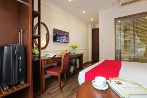 河内河内拉维贤酒店的酒店客房配有一张床、一张书桌和一台电视。