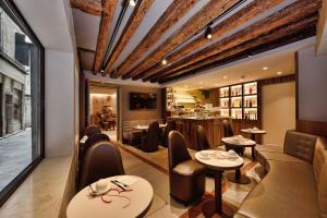 威尼斯罗莎萨尔瓦酒店的一间带桌椅的餐厅和一间酒吧