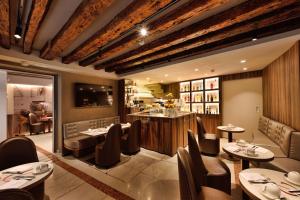威尼斯罗莎萨尔瓦酒店的一间带桌椅的餐厅和一间酒吧