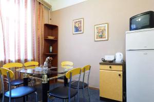 基辅拉维特斯托果之家公寓酒店的一间带桌子和冰箱的用餐室