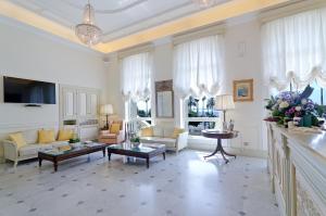圣雷莫巴黎圣雷莫酒店的大型客厅配有白色家具和吊灯。