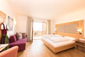 维兰德罗Panorama Hotel Flora的酒店客房设有两张床和一张紫色椅子