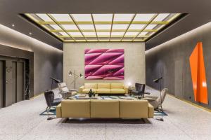 巴塞罗那杰拉德室友酒店的客厅配有黄色沙发和粉红色的绘画