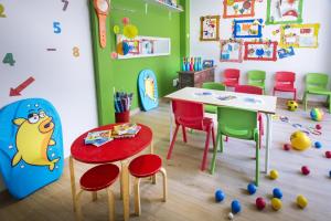 卡拉费尔4R Miramar Calafell的幼儿园教室,配有桌椅和桌子