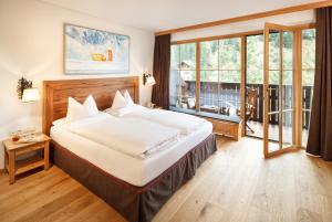 莱赫阿尔贝格莱赫及樵萨罗莎酒店的一间卧室设有一张大床和一个大窗户