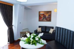 斯特鲁加梦想酒店的客厅配有沙发和鲜花桌