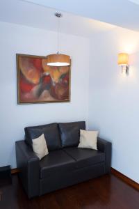 斯特鲁加梦想酒店的客厅里一张黑色的沙发,上面有绘画作品