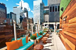 纽约时代广场圣殿酒店的一座带五颜六色的桌椅的屋顶露台,一座城市