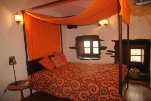 Sobreira FormosaAldeia Oliveiras的一间卧室配有一张带橙色天篷的床