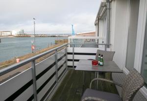 黑尔戈兰岛Appartements am Binnenhafen的阳台配有桌椅,享有水景。