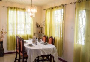 圣彼得教区Darrel Cot Beachfront Cottage的一间设有桌子和黄色窗帘的用餐室