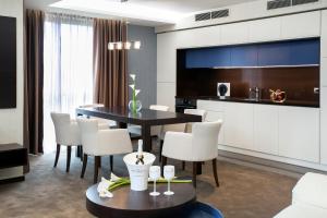 索非亚维科精品公寓酒店的一间带桌子和白色椅子的用餐室