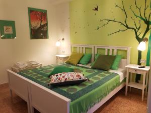 墨西拿B&B Caronte Messina的卧室配有一张床铺,墙上挂着一棵树