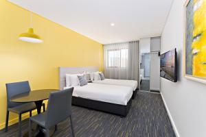 悉尼绿色广场价值酒店的酒店客房配有一张床铺和一张桌子。