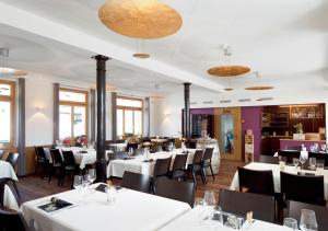 弗鲁蒂根奈西奥纳酒店的用餐室配有白色桌子和黑色椅子