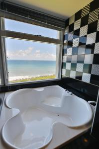 盐寮白浪滔滔民宿 的带浴缸的浴室和海滩窗户。