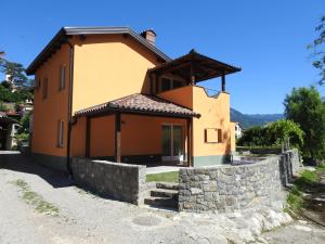 DobravljePočitniška Hiša的一座黄色的小房子,带有石墙