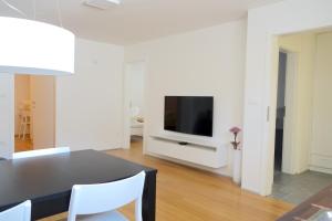 卢布尔雅那Sensei apartment的客厅配有餐桌和电视