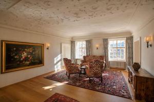 塞考Hotel Hofwirt的客厅配有椅子和天花板上的绘画