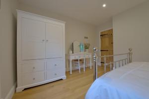 霍尔特Pippin Heath House B&B的卧室配有大型白色橱柜和桌子