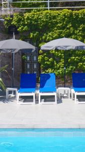 圣玛丽亚波焦索尔埃迈尔公寓式酒店的游泳池畔的2把蓝色椅子和遮阳伞