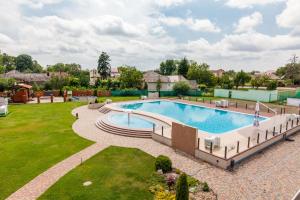 乌日霍罗德Zinedine Sport-Hotel的一座带绿色草坪的庭院内的大型游泳池