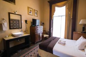 梅里达艾尔格兰酒店的一间卧室配有床、水槽和镜子