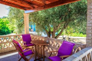 瓦西里科斯波尔图格拉卡斯别墅的门廊配有紫色椅子和木桌