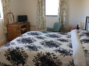 米勒姆HH Accommodation的一间卧室配有一张床、一张书桌和一个窗户。