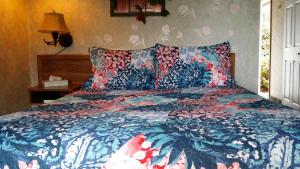 科达伦贝内特湾旅馆的一间卧室配有一张带蓝色和红色棉被的床