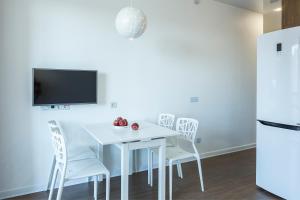 伊尔库茨克市中心欧丁公寓的白色的餐桌、白色的椅子和电视