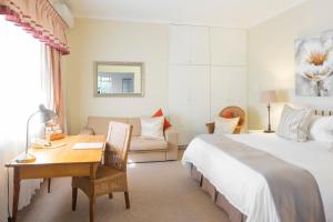 伊丽莎白港翠鸟旅馆的酒店客房带一张床铺、一张书桌和一间卧室