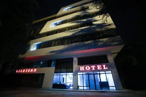 库塔伊西West Tower Hotel的夜间带有酒店标志的酒店大楼