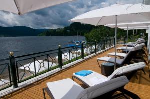 蒂蒂湖-新城Treschers Schwarzwald Hotel的水面上带椅子和遮阳伞的甲板