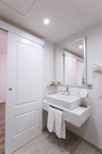 托里霍斯Hospedium Hotel Castilla的白色的浴室设有水槽和镜子