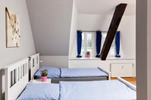 PrisdorfBett4-you Pinneberg - Prisdorf的配有蓝色窗帘的客房内的两张床