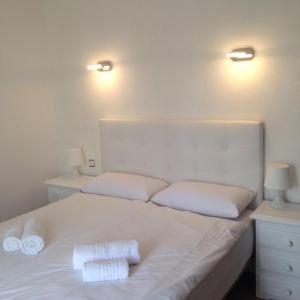 卡拉达沃黄金之家旅馆的一张带两个白色枕头和两个灯的白色床