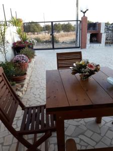 科尔萨诺Bilocale jasmin的天井上配有一张带两把椅子和鲜花的木桌