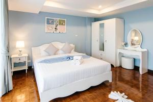 考陶SeaRidge Hua Hin Resort & Poolvilla的卧室配有白色的床和镜子