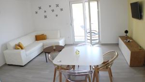 普罗马尼亚Apartments Danica的客厅配有白色的桌子和椅子