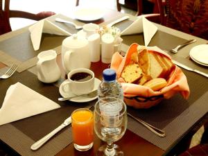 沙迦阿贝拉精品酒店的一张桌子,上面放着一篮面包和一瓶果汁