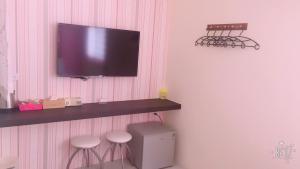 吉安小敏&日森民宿的一间设有壁挂式电视及凳子的房间