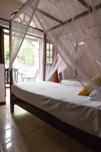 尼甘布维拉塔普洛班住宿加早餐旅馆的一张床上的蚊帐