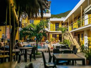 塔甘加Hostel Nirvana Taganga的一个带游泳池和桌椅的度假酒店