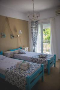 斯卡拉马里昂Maistrali Pension的一间卧室设有两张床和窗户。
