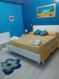 扎费拉纳-埃特内阿Etna En Vie的一间卧室设有一张蓝色墙壁的大床