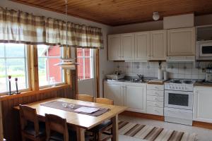 迪韦德Backs Semesterby的厨房配有白色橱柜和木桌