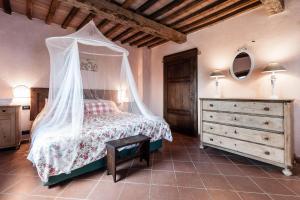 Montecastelli彻尔巴约拉村酒店的一间卧室配有一张带天蓬的床