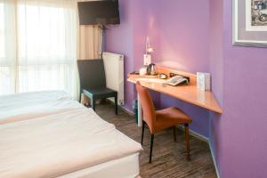 汉诺威汉诺威朗根哈根氛围酒店 - 郁金香酒店管理的酒店客房配有一张床、一张书桌和一部电话